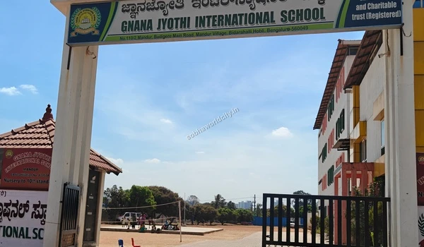 View through the gates showing the spacious school playground at Gnana Jyothi International School near the Sobha World City residential area