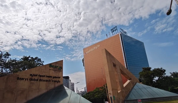 Tall glass facade of the Bearys Global Research Triangle building representing the prime employment hubs around Sobha World City
