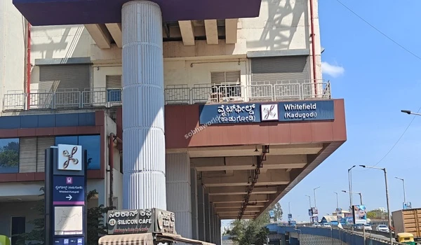 Bustling street level scene showing BMTC buses and auto rickshaws at the Whitefield metro station servicing Sobha World City