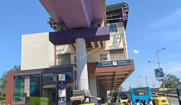 Active public transport stop at Whitefield showing a blue city bus arriving at the metro station near Sobha World City