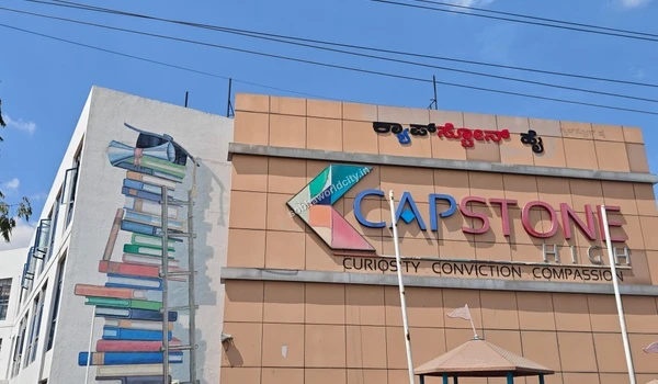 Exterior view of the vibrant Capstone High campus featuring an artistic book mural, highlighting the excellent educational facilities located near the premium Sobha World City development.