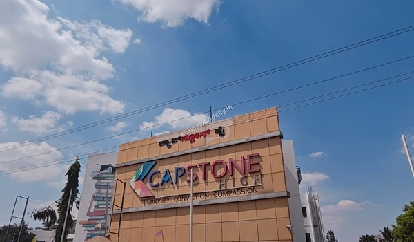Low angle shot of the Capstone High building against a clear sky, an educational landmark in the vicinity of Sobha World City.