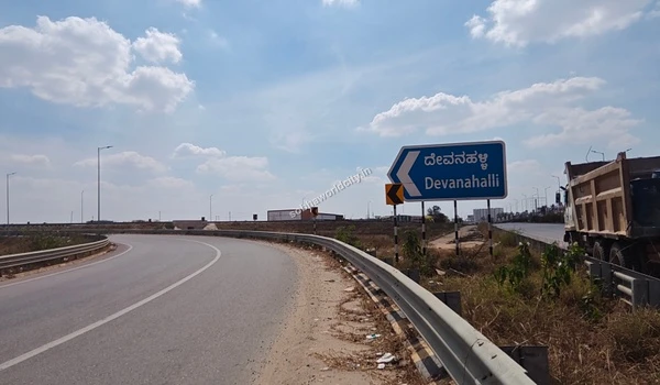 Bright daytime view of the highway marker directing traffic to Devanahalli, demonstrating the prime commute options near Sobha World City.