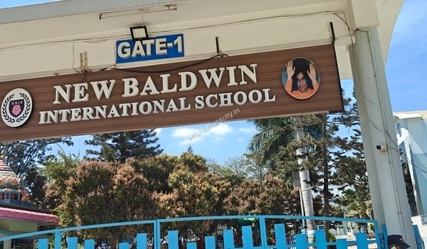 Detailed view of the school entrance sign with trees and campus greenery surrounding the educational facility near Sobha World City