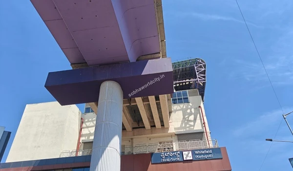 Looking up at the purple elevated metro tracks and architectural supports at Kadugodi station showcasing rapid transit infrastructure near Sobha World City