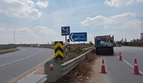 Wide highway curve accommodating heavy transport vehicles near the NE-7 entry, demonstrating the exceptional transport capacity surrounding Sobha World City.