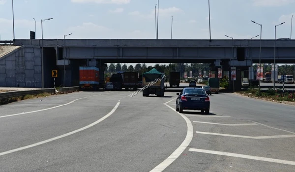 A panoramic view of the wide highway approach leading towards the Sobha World City intersection, ensuring smooth daily commutes.