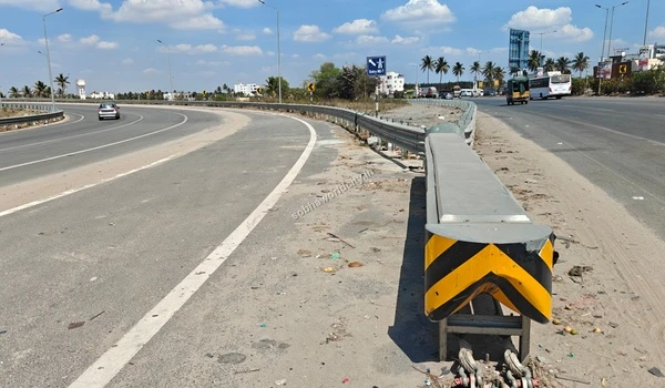 Close-up view of the highway guardrail separating the fast Kolar lane from the Hosur Road turning lane, emphasizing safe travel at Sobha World City.