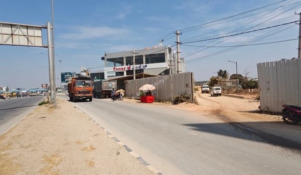A clear view of the turnoff from KR Puram Hoskote Road onto the dirt access road leading into the Sobha World City property.
