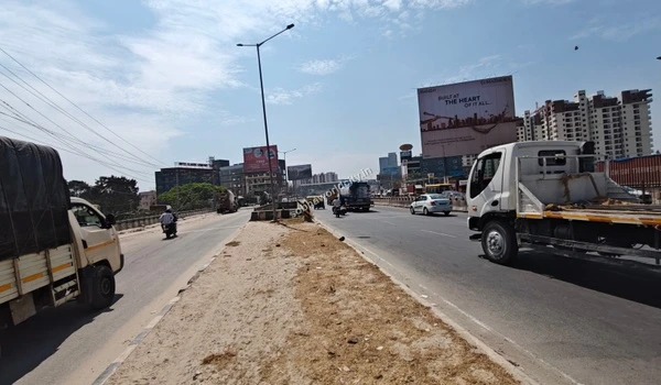 Daily traffic flow including commercial vehicles on the multi-lane highway heading towards Hoskote from the Sobha World City project site.