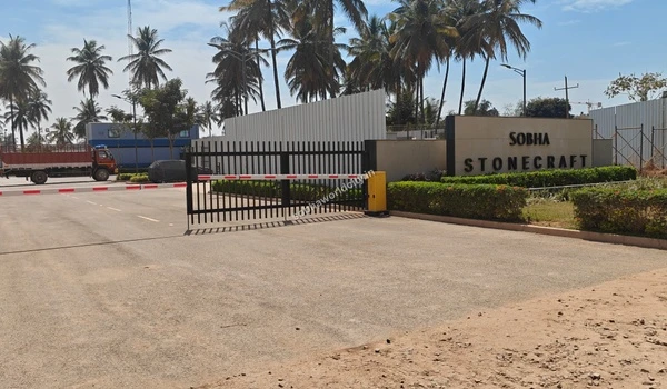 Secured industrial gate and boom barrier next to the Sobha Stonecraft display wall at Sobha World City