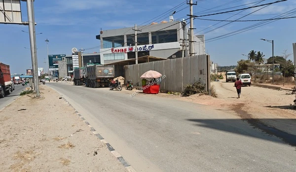 Street level perspective of the KR Puram Hoskote Road corridor showing the direct turnoff into the Sobha World City project site.