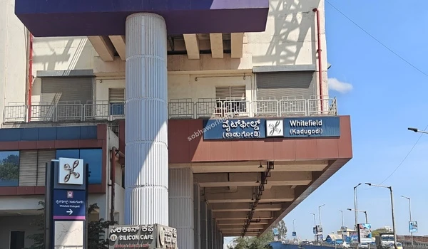 Wide view of the Whitefield Kadugodi metro station exterior and entrance structure near the Sobha World City project