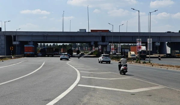 Local two-wheeler commuters enjoying a wide and well-paved road network that leads directly to the prominent Sobha World City area.