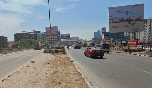 Cars and buses navigating the wide, multi-lane road leading towards Hoskote, underscoring the strategic location and connectivity of Sobha World City.