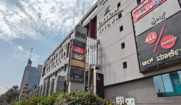 Detailed view of the multi-level shopping complex facade highlighting popular clothing brands near Sobha World City