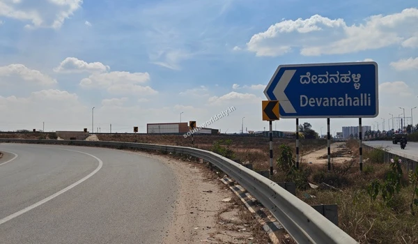 View of the Entry NE-7 signage alongside the Devanahalli route marker, indicating rapid expressway access from Sobha World City.