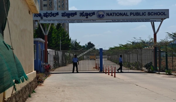 Vigilant security personnel stationed at the National Public School gate, providing a secure environment near Sobha World City.