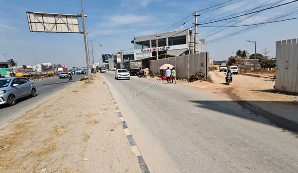 Excellent connectivity demonstrated by the entrance of Sobha World City branching off the main KR Puram Hoskote Road next to local vendors.