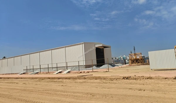 White metal perimeter fencing separating the sandy construction area from the external surroundings at Sobha World City