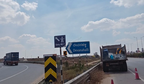 Close-up view of the safety chevron signs and NE-7 entry marker, indicating rapid and safe expressway access from the Sobha World City development.