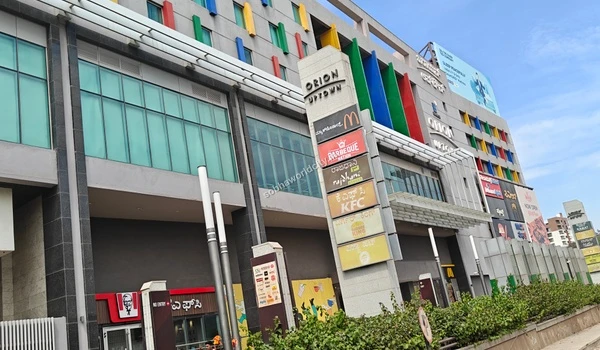 Close-up of retail brand signage including top clothing and footwear stores situated in the Sobha World City neighborhood