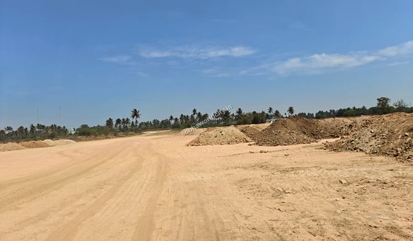 Wide sandy pathway with excavated dirt mounds along the side at the Sobha World City site