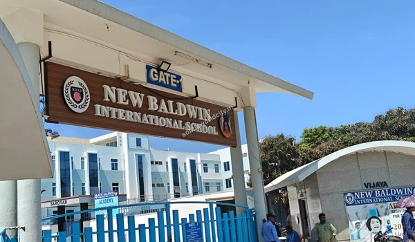 Large wooden signage displaying New Baldwin International School at the primary entrance near Sobha World City
