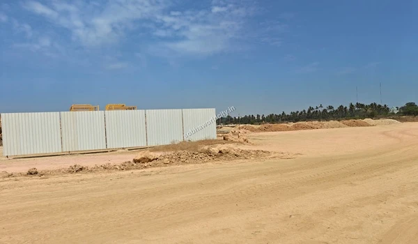 Temporary white metal barricades installed at the boundary of the Sobha World City construction site