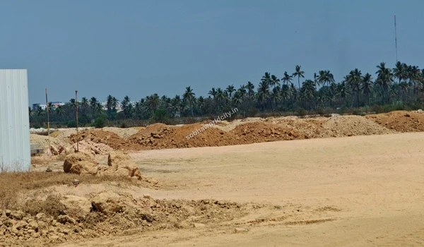 Rocky earth mounds near the white metal boundary barricades of the Sobha World City project