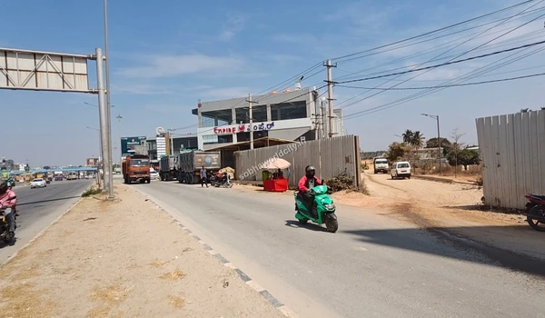 Close up view of the unpaved entrance path to the Sobha World City project site directly accessible from the Old Madras Road highway.