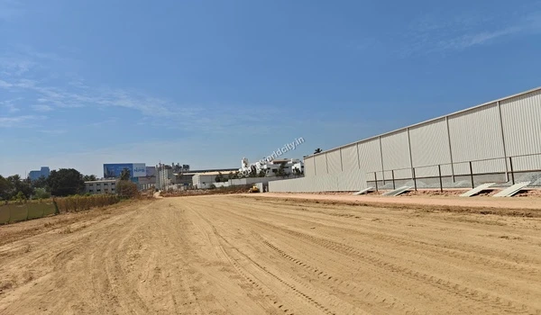 Wide view of the site storage facility constructed along the dirt access road at Sobha World City