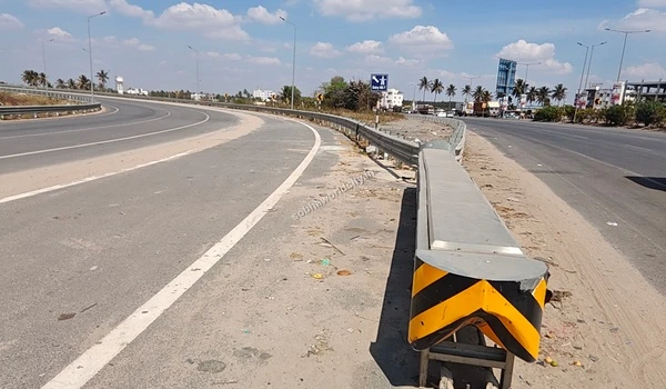 The physical road barrier guiding outgoing traffic smoothly onto the Hosur Road ramp while main highway traffic proceeds to Kolar by Sobha World City.