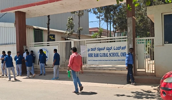 Security personnel guiding parents at the Shri Ram Global gates ensuring order and safety near the Sobha World City area