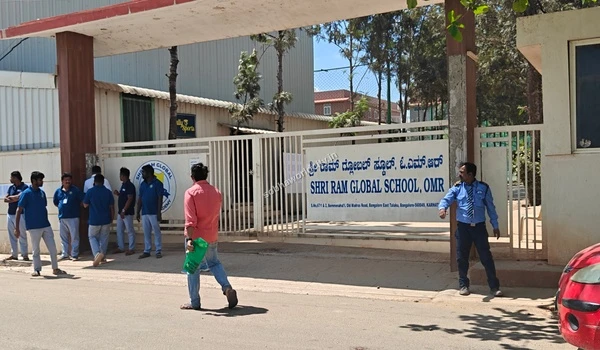 Staff members standing outside the Shri Ram Global School facilitating easy drops for children from Sobha World City