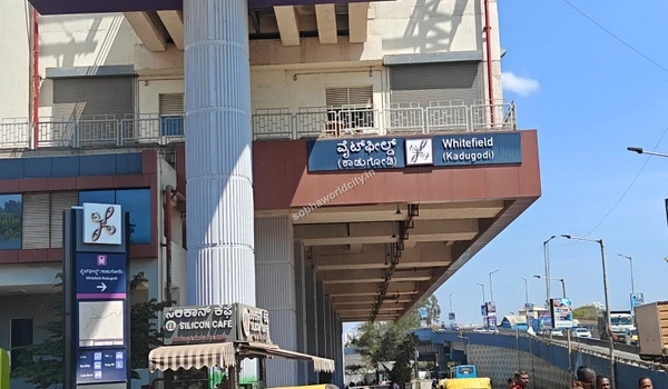 Clear daytime shot of the Whitefield metro station entrance board and overhead tracks accessible from Sobha World City