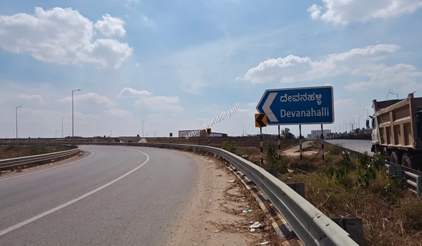 Auto rickshaw traveling past the strategic location signage pointing to the airport and Dabaspete, steps away from Sobha World City.