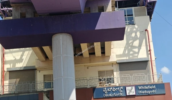 Clear daytime visibility of the Kannada and English station name boards at the Whitefield stop near Sobha World City