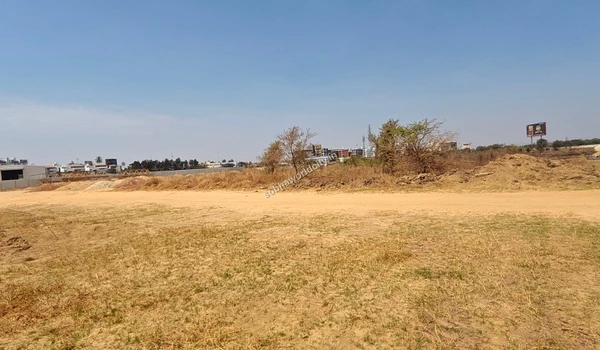 Close view of a white construction shed and yellow metal trusses at Sobha World City